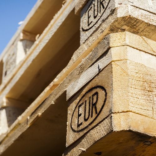 Nahaufnahme von gestapelten Holzpaletten mit dem Stempel 'EUR' auf der Ecke
